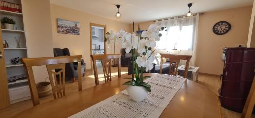a living room with a table with a vase of flowers on it at El Mirador de Segovia in Basardilla