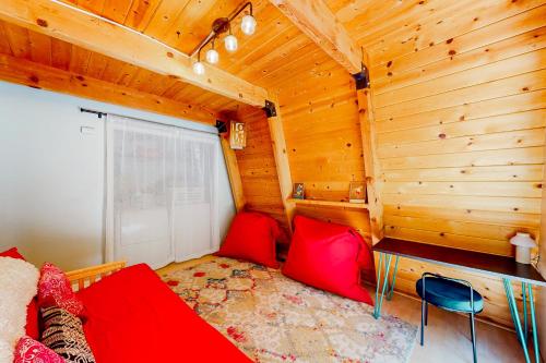 a living room with a red couch in a wooden room at Hidden Wonder in Crestline