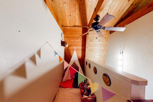 a room with a ceiling fan and a room with a staircase at Hidden Wonder in Crestline
