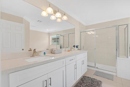 a white bathroom with a sink and a shower at South Florida vacation home in Coral Springs