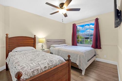 a bedroom with two beds and a ceiling fan at South Florida vacation home in Coral Springs