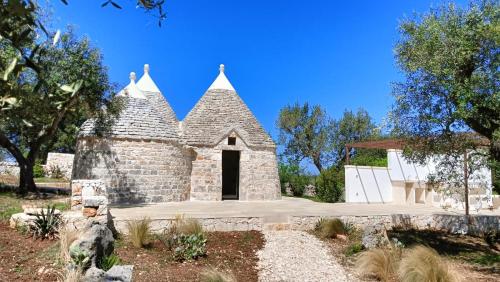 a small stone church with a black door at Trullo Pettirosso Ostuni in Ostuni