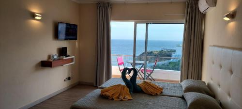 a room with a couch with a view of the ocean at Estrela do Mar in Albufeira
