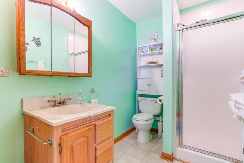a bathroom with a sink and a toilet and a mirror at Kayak, Fish, Boat and Swim Home Near Lakeside Park! in Woodland Beach