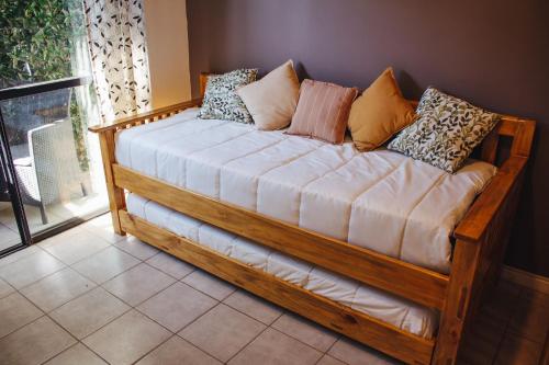 门多萨Acacia的一张带枕头的木制沙发