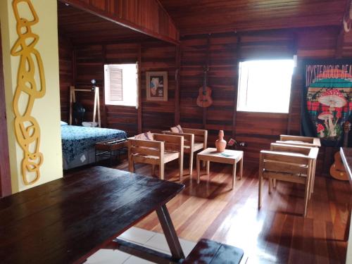 a room with wooden walls and a table and chairs at Chalé Penedo in Penedo