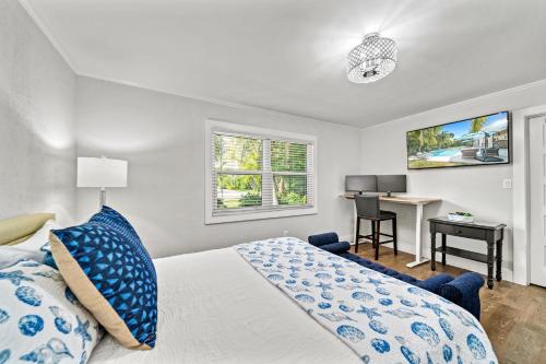a bedroom with a bed with blue pillows and a desk at Coconut Cottage - 422 in Bailey Hall