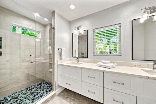 a white bathroom with a shower and a sink at Coconut Cottage - 422 in Bailey Hall