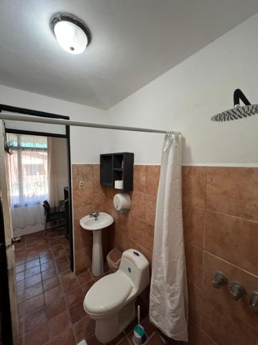 a bathroom with a toilet and a sink at La Flor de Coco in Sámara