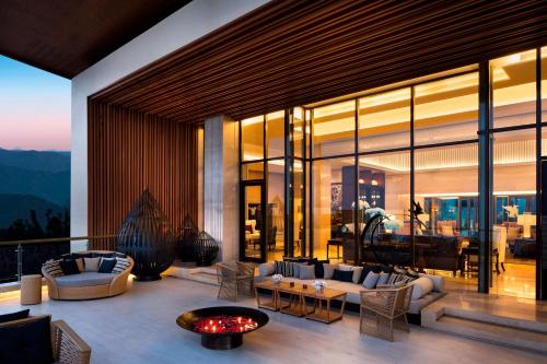 a living room with couches and a table at JW Marriott Mussoorie Walnut Grove Resort & Spa in Mussoorie