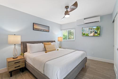 ein Schlafzimmer mit einem großen weißen Bett und einer Lampe in der Unterkunft The Beachy Keen - U in Siesta Key