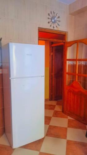 a white refrigerator in a kitchen with a checkered floor at CASA RAYAN in Chefchaouene