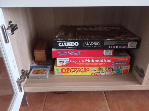a stack of books sitting on a shelf in a cabinet at Casa Rural El Algarrobo in Utrera