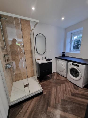une salle de bain avec douche et machine à laver dans l'établissement Maison proche Omaha Beach, à Grandcamp-Maisy