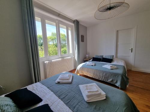 une chambre avec deux lits et une fenêtre dans l'établissement Maison proche Omaha Beach, à Grandcamp-Maisy