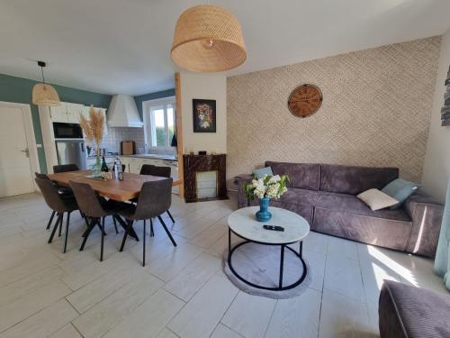 un salon avec un canapé et une table dans l'établissement Maison proche Omaha Beach, à Grandcamp-Maisy
