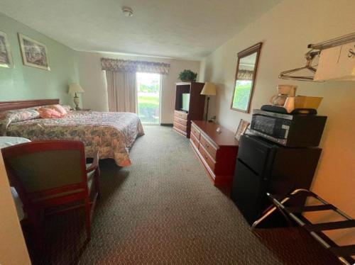 Habitación de hotel con 2 camas y TV en Colonial Brick Inn & Suites en Susquehanna