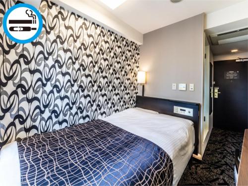 een slaapkamer met een bed met een muur met patronen bij APA Hotel Osaka Higobashi Ekimae in Osaka