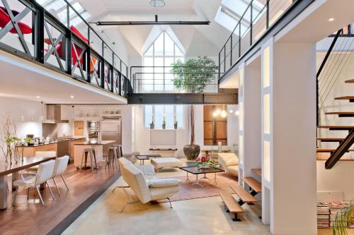 Il comprend un salon décloisonné avec une salle à manger et une cuisine. dans l'établissement Luxury Two-Story Designer Loft in Paris Epicenter - Bright and Spacious, à Paris