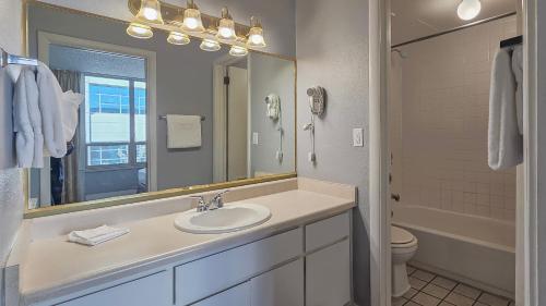 La salle de bains est pourvue d'un lavabo, d'un miroir et de toilettes. dans l'établissement Legacy Vacation Resorts - Reno, à Reno