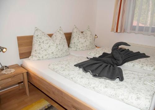 a bedroom with a bed with a black towel on it at Ferienwohnungen Hecher in Feldkirchen in Kärnten