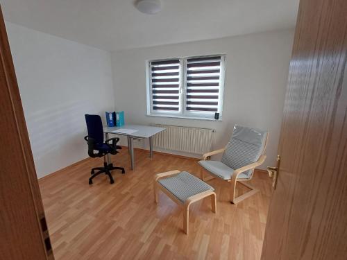 Zimmer mit einem Schreibtisch, 2 Stühlen und einem Tisch in der Unterkunft Naturerlebnis Ferienhaus in Neunkirchen