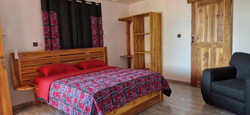 a bedroom with a bed and a blue chair at ROBINSON PLAGE Appartement in Lomé
