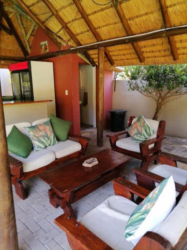 a patio with couches and a table and chairs at Hhusha Hhusha in Malelane
