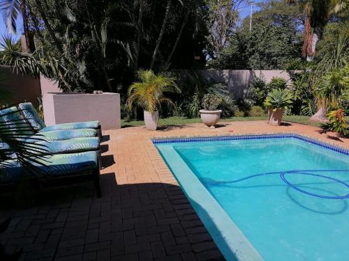 a swimming pool with a chair and a hose on it at Hhusha Hhusha in Malelane