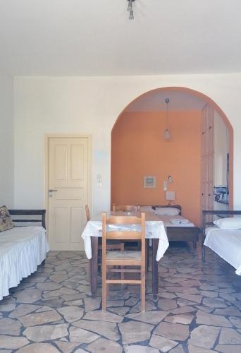 a room with a table and a room with two beds at Vocamvilia Apartments in Kamari