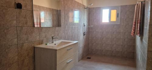 a bathroom with a sink and a shower at Appartement ROBINSON PLAGE in Lomé