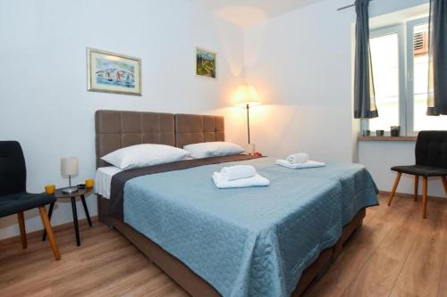 a bedroom with a bed with two towels on it at Rooms Patricija 2 in Zadar