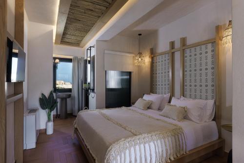 a bedroom with a large bed with white pillows at Aja Retreat Luxury Suites in Kamari