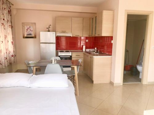 a kitchen with red cabinets and a table with chairs at Gorgona Di Thassos in Limenaria