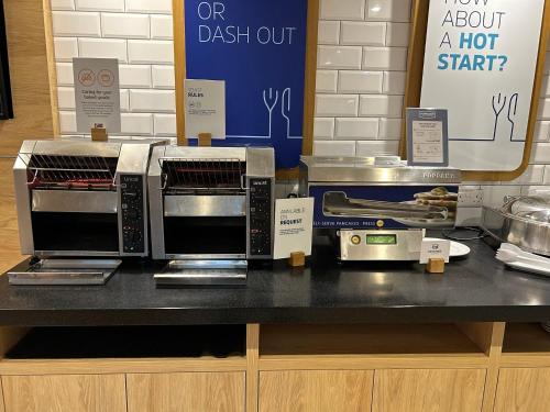 eine Theke mit zwei Mikrowellen darauf in der Unterkunft Holiday Inn Express Swindon City Centre by IHG in Swindon