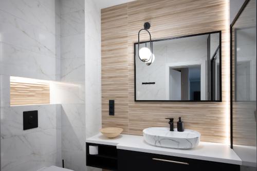 een badkamer met een witte wastafel en een spiegel bij Apartament Sosnowy przy Basenach Tropikalnych, prywatny parking, faktura in Kielce
