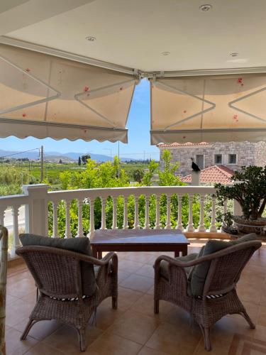 een veranda met 2 stoelen en een tafel op een balkon bij My Paradise in Asíni