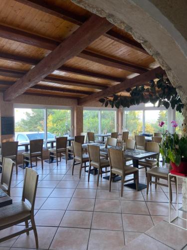 a dining room with tables and chairs and windows at Les Belles Terrasses in Tourrettes-sur-Loup