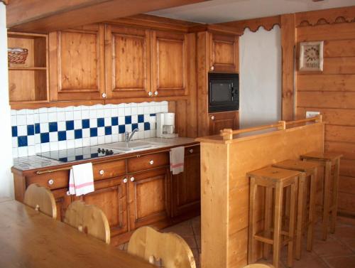 a kitchen with wooden cabinets and a sink at Appartments in Tignes Ecrin des Neiges in Tignes