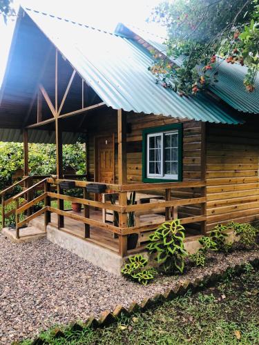 uma pequena cabana de madeira com um telhado de estanho em Cabaña de campo en el lago de yojoa em Santa Cruz de Yojoa