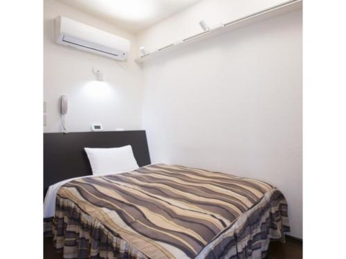 a bedroom with a bed in a white room at Hotel Tetora Tsurumi - Vacation STAY 37288v in Yokohama