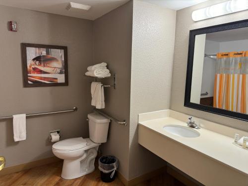 a bathroom with a toilet and a sink and a mirror at La Quinta by Wyndham Bannockburn-Deerfield in Bannockburn