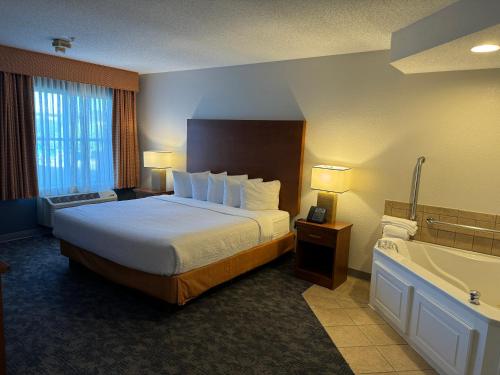 a hotel room with a bed and a bath tub at La Quinta by Wyndham Bannockburn-Deerfield in Bannockburn