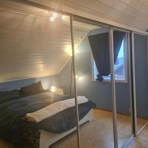 a bedroom with a bed and a window at GG overnatting in Stavanger
