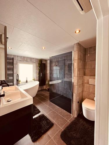 a bathroom with a tub and a toilet and a sink at B&B Prachtig Allemachtig in Valkenburg