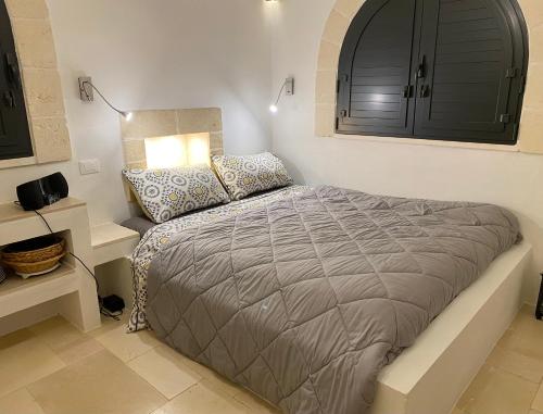 ein Schlafzimmer mit einem Bett, einer Lampe und einem Schrank in der Unterkunft NEW SHEPHERD HOUSE, CAROVIGNO, 2 Adults + 1 child in Carovigno