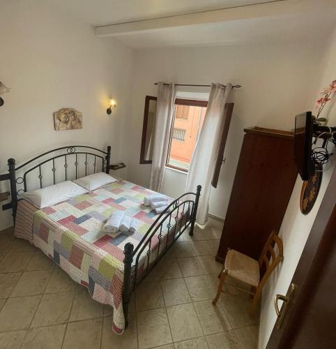 a bedroom with a bed and a television and a window at MAESTRALE B&B in Arbus