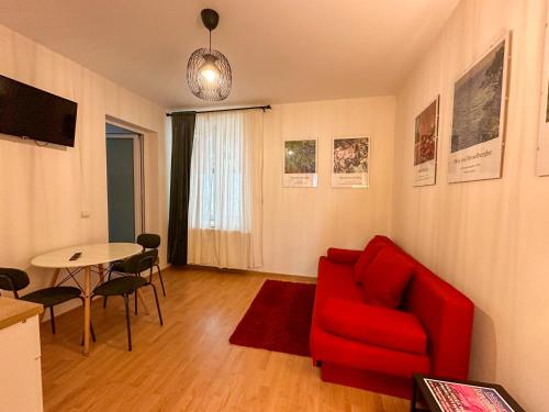 sala de estar con sofá rojo y mesa en Serenity House Apartments en Sibiu