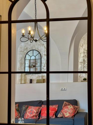 a view through a window of a couch with pillows at Serenity House Apartments in Sibiu