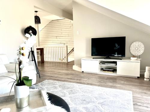 una sala de estar con TV de pantalla plana en un armario blanco en Latakia - Heritage Tay Basin Waterfront Maisonette, en Perth